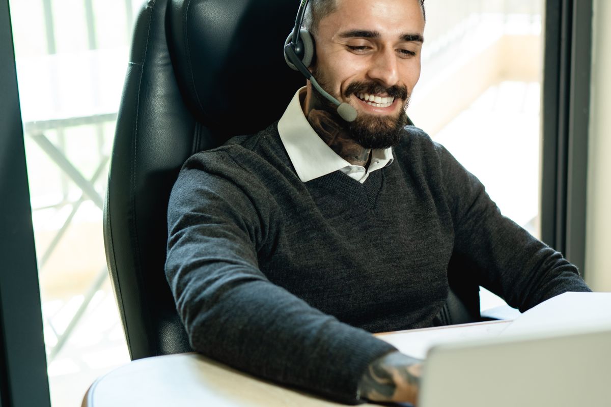 Atendente com fone de ouvido sorrindo enquanto trabalha